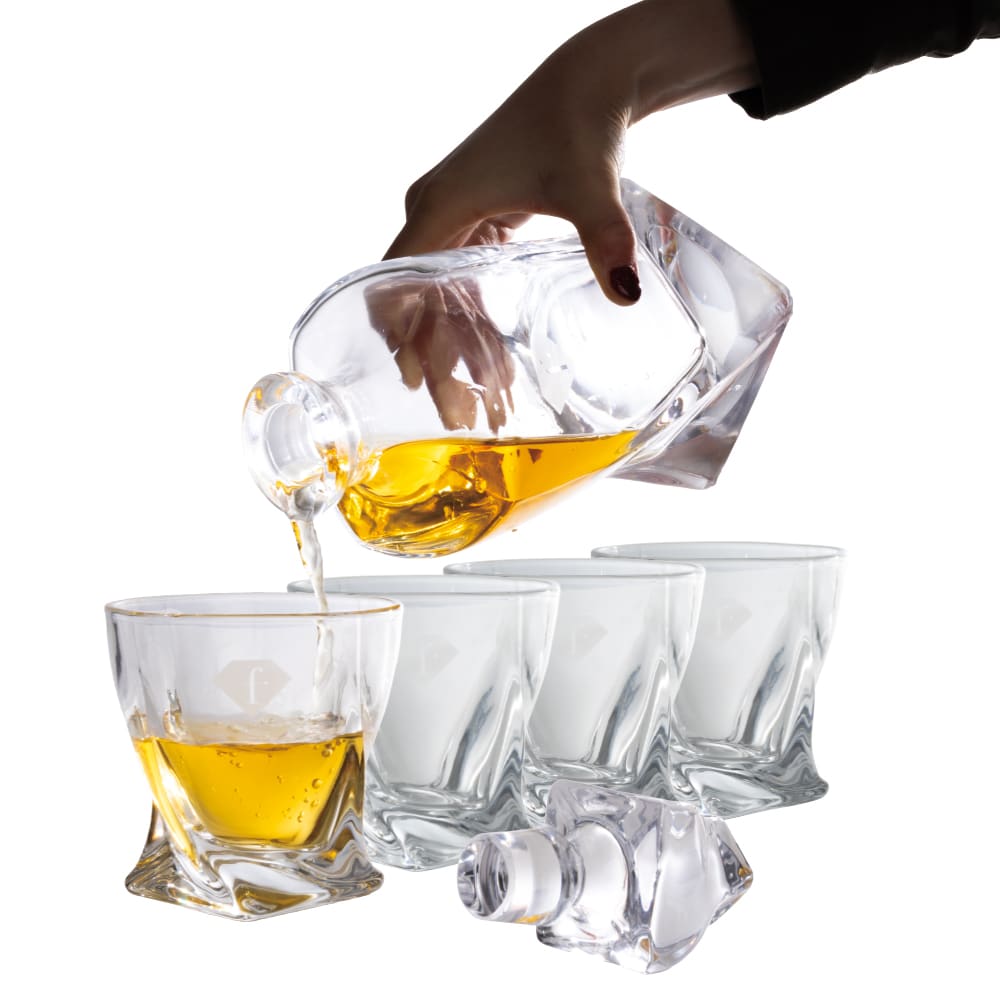 Whiskyszett 4 pohárral és üvegdekanterrel. Ital kitöltése a kancsóból az üvegpohárba.